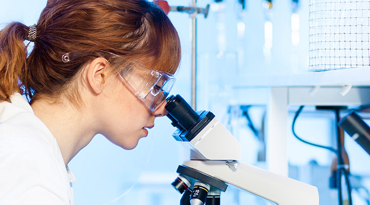 researcher looking into microscope